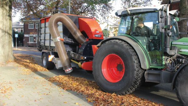 Vacuum trailer collecting leaves with suction hose