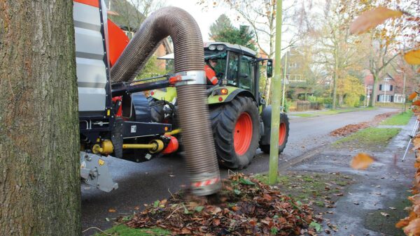 Vacuum trailer with suction hose collecting leaves