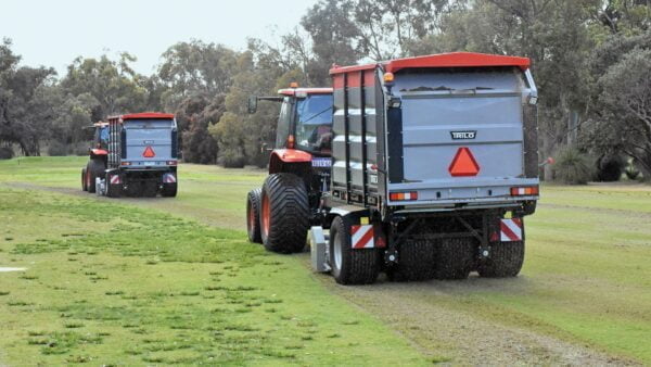 Vacuum trailers verticutting and collecting on a golf course